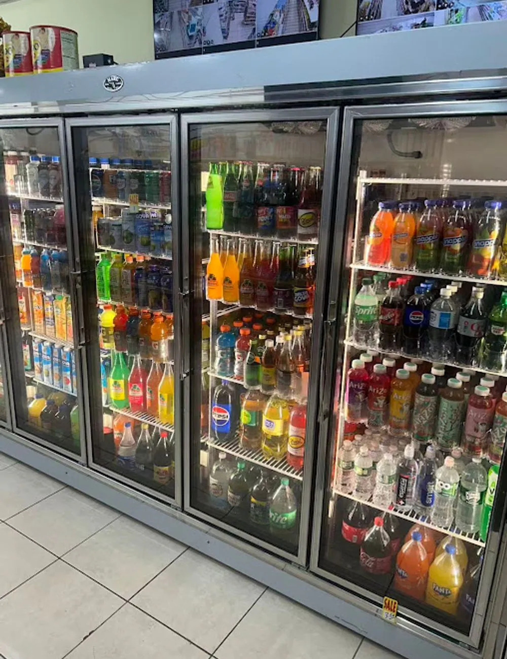 Refrigerated coolers with assorted bottled drinks at 105 Mini Market, a Supermarket & Fast Food Spot in Corona