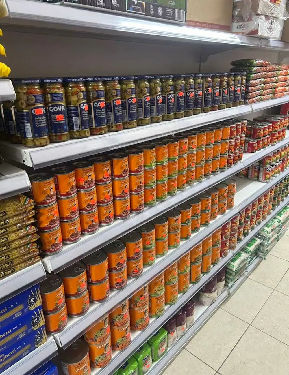 Shelves lined with canned goods and pasta products at 105 Mini Market, a Supermarket & Fast Food Spot in Corona